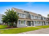 Well-maintained townhome featuring gray siding, blue shutters, and manicured landscaping, creating a welcoming curb appeal at 1891 Colony Dr. # 15 J, Surfside Beach, SC 29575