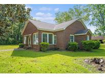 Charming brick home featuring large windows and a well-maintained lawn, perfect for suburban living at 1895 Bucksville Dr., Conway, SC 29527