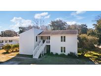 Charming two-story home with white siding and inviting stairs to a second level porch at 2005 Havens Dr., North Myrtle Beach, SC 29582