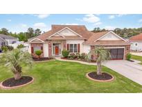 Charming single-story home featuring a lush lawn, mature palms, and a welcoming red front door at 2191 Deerfield Ave., Surfside Beach, SC 29575