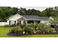 Charming single-story home featuring a well-manicured lawn and beautiful landscaping, complemented by dark shutters at 2529 Hunters Trail, Myrtle Beach, SC 29588