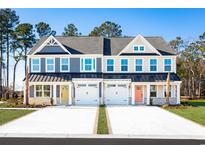 Inviting two-story townhomes featuring colorful doors, attached garages, and beautifully landscaped front yards at 2605 Elowen Ln. # 103B, Longs, SC 29568
