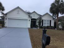 Charming single-story home with well-manicured landscaping and a two-car garage at 3012 Winding River Rd., North Myrtle Beach, SC 29582