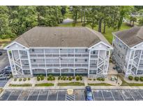 Aerial view of condo building showcasing multiple units and ample parking space at 4787 Wild Iris Dr. # 303, Myrtle Beach, SC 29577