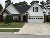 Charming home featuring brick accents, a well-manicured lawn, and a two-car garage at 4818 Harvest Dr., Myrtle Beach, SC 29579