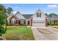 Charming single-Gathering home with a brick and vinyl exterior, complemented by a well-manicured lawn at 4818 Harvest Dr., Myrtle Beach, SC 29579