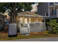Charming yellow cottage with a welcoming front porch, string lights, and a cozy beach vibe at 6001 - 1820A S Kings Hwy., Myrtle Beach, SC 29575