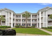 Charming condo building with private balconies and lush landscaping under a clear blue sky at 637 Waterway Village Blvd. # 13C, Myrtle Beach, SC 29579