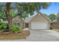 Charming single-Gathering home with a well-maintained lawn, mature trees, and a two-car garage at 775 Kittiwake Ln., Murrells Inlet, SC 29576
