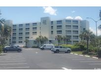 Condo exterior with parking lot and neatly landscaped grounds showcasing beachside living at 9400 Shore Dr. # 507, Myrtle Beach, SC 29572
