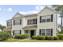 Inviting two-story home featuring black shutters, manicured lawn, and charming curb appeal at 1065 Harvester Circle, Myrtle Beach, SC 29579