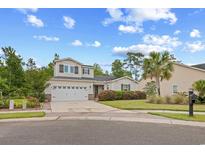 Charming two-story home with a manicured lawn, palm tree, and two car garage, offering curb appeal at 1444 Thames Ct., Myrtle Beach, SC 29577