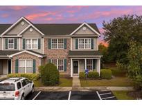 Charming townhome showcasing brick and siding, complemented by lush landscaping and a welcoming entranceway at 151 Chenoa Dr. # 35-F, Murrells Inlet, SC 29576