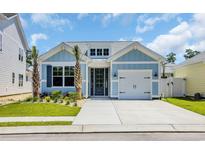 Charming single-Gathering home with blue siding, landscaping, and a one-car garage at 1533 Coastal Cove Ln, Calabash, NC 28467