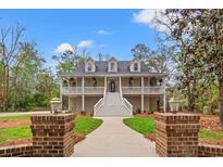 Inviting two-story home featuring a spacious front porch and meticulously landscaped front yard at 1533 Murrells Landing Rd., Conway, SC 29526