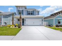 Charming two-story home featuring a two-car garage, a well-manicured lawn, and beautiful exterior paint at 1549 Coastal Cove Ln, Calabash, NC 28467