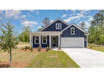 Charming blue home with a well-manicured lawn and attached two-car garage at 1829 Hardwood Ct., Conway, SC 29526