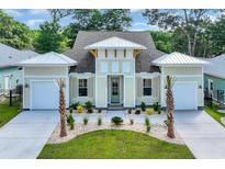 Stunning home with a well-manicured lawn, a two-car garage and charming light-green shutters at 1936 Indigo Cove Ln, Calabash, NC 28467