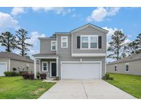 Two-story home featuring a garage, black door, and neatly maintained landscaping at 2059 Borgata Loop, Longs, SC 29568