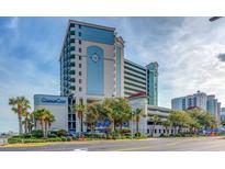 Beautiful exterior of the Compass Cove resort with palm trees and manicured landscaping at 2301 S Ocean Blvd. # 621, Myrtle Beach, SC 29577