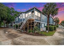 Charming home with a wooden staircase leading to the front porch, complemented by lush landscaping at 299 Lake Arrowhead Rd., Myrtle Beach, SC 29572