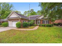 Charming brick home featuring an attached garage and a well-manicured front lawn at 2995 Woodberry Ct., Little River, SC 29566
