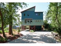 Unique coastal home on stilts with gravel driveway and lush landscaping at 329 Kauffman St., Georgetown, SC 29440