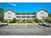 Exterior shot of a three-story condo building with white balconies and well-maintained landscaping at 4811 Innisbrook Ct. # 306, Myrtle Beach, SC 29579