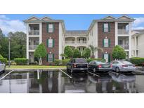 A multi-story condo building with brick and white siding, balconies, and parking at 488 River Oaks Dr. # 61N, Myrtle Beach, SC 29579