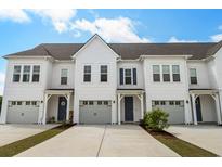 Charming townhomes with white siding, gray garages, and blue front doors create inviting curb appeal at 5127 Double Eagle Way # 11, North Myrtle Beach, SC 29582