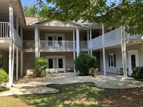 Charming condo exterior showcasing private balconies with white railings and landscaped courtyard at 5206 Sweetwater Blvd. # 5206, Murrells Inlet, SC 29576