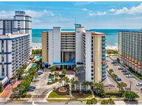 Beautiful oceanfront condo building with palm trees, a pool, and stunning beach views at 5300 N Ocean Blvd. # 1208, Myrtle Beach, SC 29572