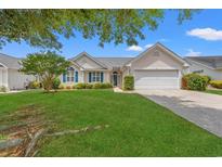 Charming single-story home featuring manicured lawn, blue shutters, and an attached two-car garage at 535 Wildflower Trail, Myrtle Beach, SC 29579