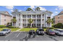 Well-maintained condo building featuring multiple levels, a parking lot, and palm trees at 633 Waterway Village Blvd # 11D, Myrtle Beach, SC 29579