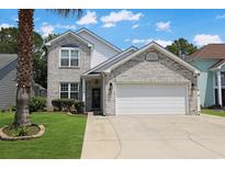 Charming two-story home with a white brick exterior, manicured lawn and two car garage at 867 Cardinal Pl., North Myrtle Beach, SC 29582
