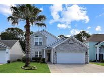 Charming two-story home with a well-maintained lawn, brick facade, and a beautiful palm tree in the front yard at 867 Cardinal Pl., North Myrtle Beach, SC 29582