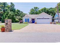 Charming ranch-style home with a well-manicured lawn, brick mailbox, and an inviting driveway leading to a two-car garage at 901 Southwind Ct., Garden City Beach, SC 29576