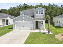 Charming two-story home featuring a well-maintained lawn, a two-car garage, and a mix of modern architectural design elements at 1146 Joywood Dr., Longs, SC 29568