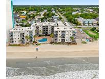 Aerial shot highlighting the building's beachfront location, pool, and ocean views at 1310 N Waccamaw Dr. # 204, Garden City Beach, SC 29576
