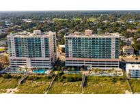 Stunning aerial view of beachfront condos with a pristine pool and manicured landscapes at 1903 S Ocean Blvd. S # 808, North Myrtle Beach, SC 29582
