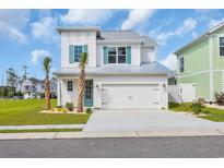 Charming two-story home with a two-car garage and nicely landscaped front yard and vibrant turquoise shutters at 1929 Indigo Cove Ln, Calabash, NC 28467