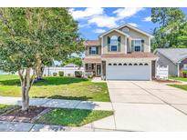 Charming two-story home featuring a manicured lawn and a two-car garage on a sunny day at 2017 Chadbury Ln., Myrtle Beach, SC 29588