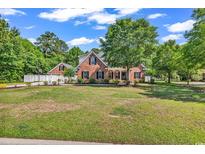 Charming brick home featuring a well-manicured lawn and mature trees offering great curb appeal at 2441 Hunters Trail, Myrtle Beach, SC 29588