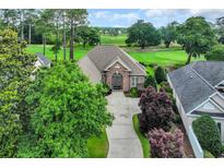 Beautiful brick home with a well-manicured lawn and a view of the golf course at 290 Dornoch Dr., Pawleys Island, SC 29585