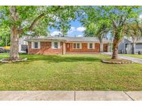 Charming single-story brick home featuring a lush, green lawn and mature trees at 3001 Wiley Dr., North Myrtle Beach, SC 29582
