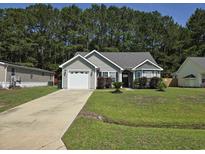 Charming one-story home with a well-manicured lawn, attached garage, and mature landscaping at 3805 Mayfield Dr., Conway, SC 29526