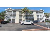 Three-story condo building with palm trees, parking, and white exterior paint in a coastal community at 400 Lands End Blvd. # 5304, Myrtle Beach, SC 29572