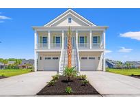 Charming two-story beach home with double garages and a inviting stairway to a cozy porch at 434 Harbour View Dr., Myrtle Beach, SC 29579