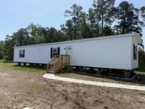 New white single-level home with a wooden porch and walkway provides great curb appeal at 500 King Air Ct, Myrtle Beach, SC 29577
