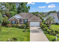 Charming brick home with well-manicured lawn, lush landscaping, and a two-car garage at 86 Black River Rd., Myrtle Beach, SC 29588